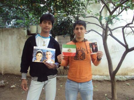 SHIFTING FROM GREEN TO BLUE ? Young Iranians boldy hold photos of Iran’s Pahlavi Royals 